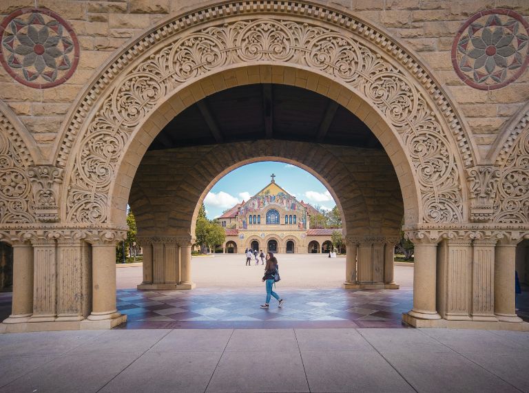 Kampus Stanford dengan Hoover Tower dan mahasiswa bersepeda di Palm Drive